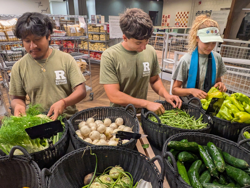 Students set up vegetables at the food pantry.