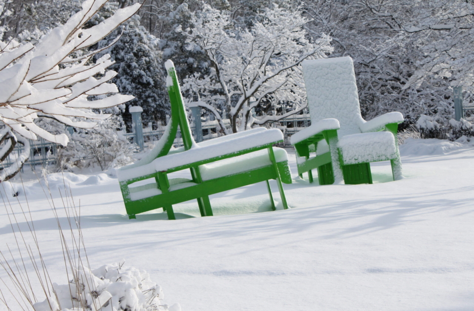 Snow on the big green chairs.
